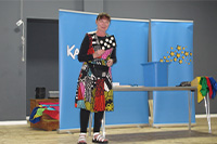 Karen Wynne yn siarad ar lwyfan